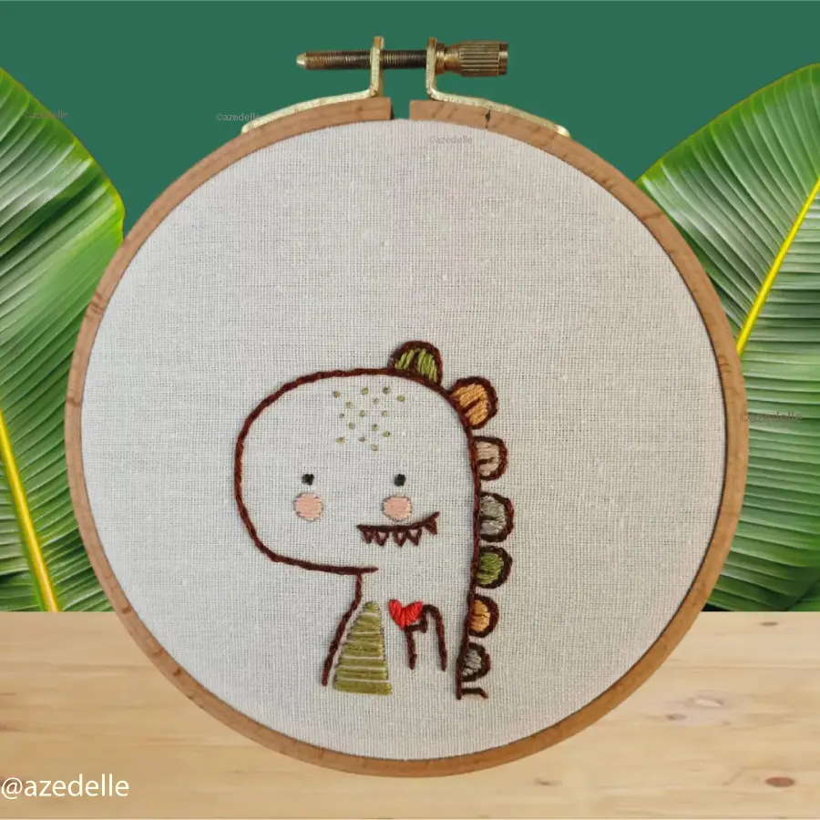 Broderie d'un dinosaure tenant un coeur dans sa main